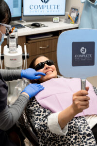 A patient at Complete Dental Works seeing her results for the first time. Consistent dental care changes more than just your teeth.