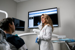dentist at Complete Dental Works explaining how to stop your teeth from falling out to a patient